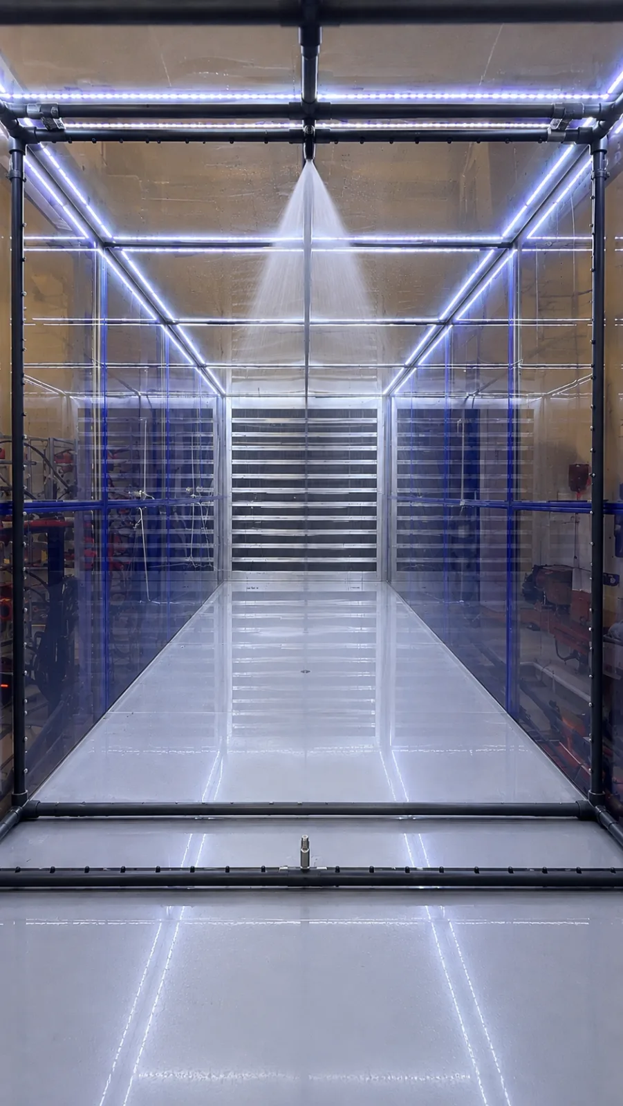 The same view with one ceiling nozzle running, throwing a single cone of spray downwards.